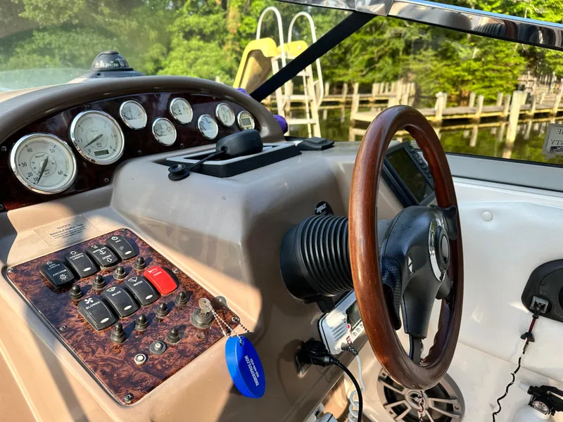 Slide: The Image of 2006 Regal Commodore boat dashboard with gauges, controls, and wooden steering wheel. - 13