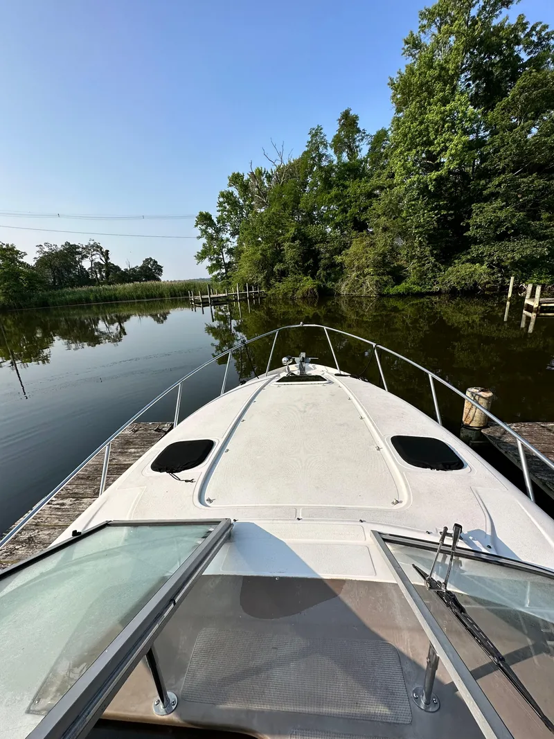 Slide: The Image of 2006 Regal Commodore boat on calm water, surrounded by lush greenery. - 4