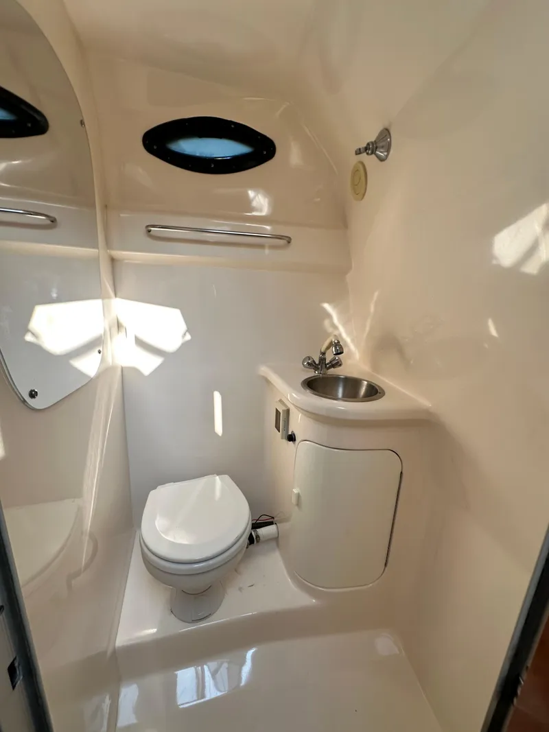 Slide: The Image of 2006 Regal Commodore boat bathroom with toilet, sink, and porthole windows. - 7