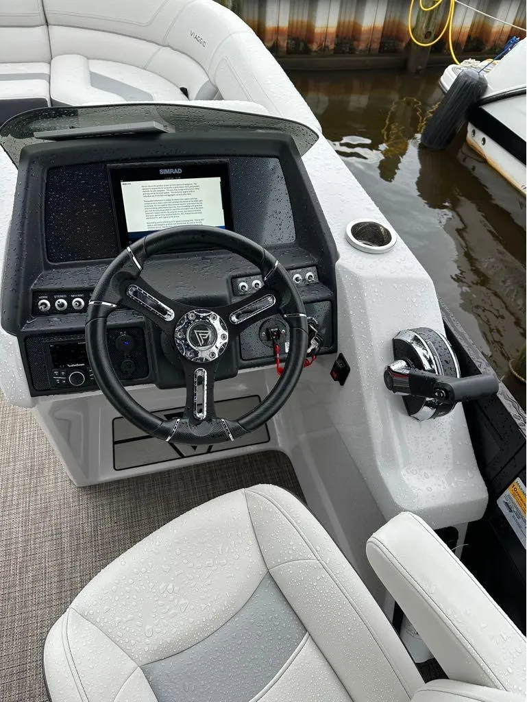 Slide: The Image of Viaggio D 23 Q 2023 boat dashboard with steering wheel and control panel, wet from rain. - 10