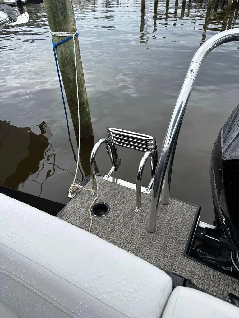 Slide: The Image of 2023 Viaggio D 23 Q boat docked, showing rear deck and ladder. - 5