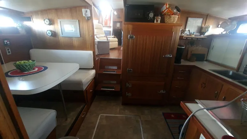 Slide: The Image of 1965 Chris-Craft 56 Roamer yacht interior with dining area and wooden cabinetry. - 11