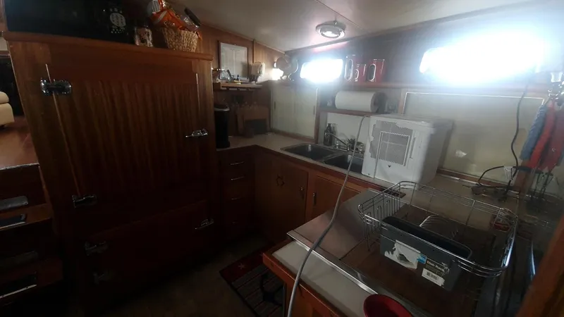Slide: The Image of 1965 Chris-Craft 56 Roamer kitchen with wooden cabinets and modern appliances. - 13