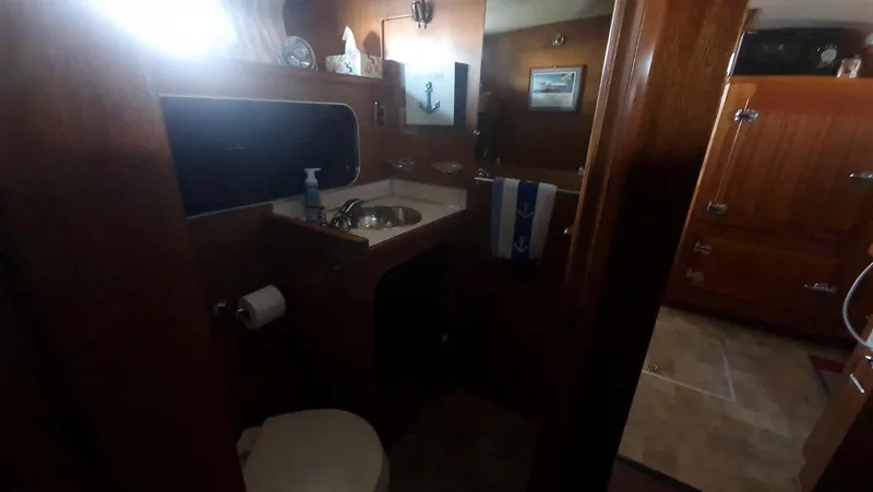 Slide: The Image of 1965 Chris-Craft 56 Roamer yacht bathroom with wooden cabinetry and sink. - 14