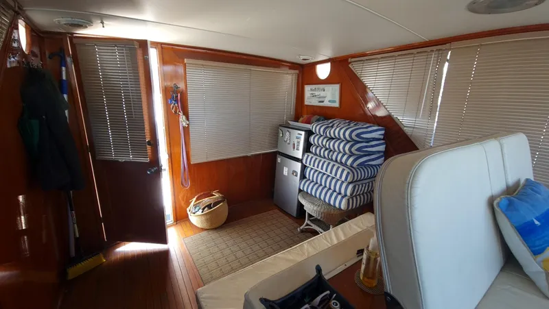 Slide: The Image of Interior of 1965 Chris-Craft 56 Roamer yacht with wooden paneling and stacked cushions. - 22