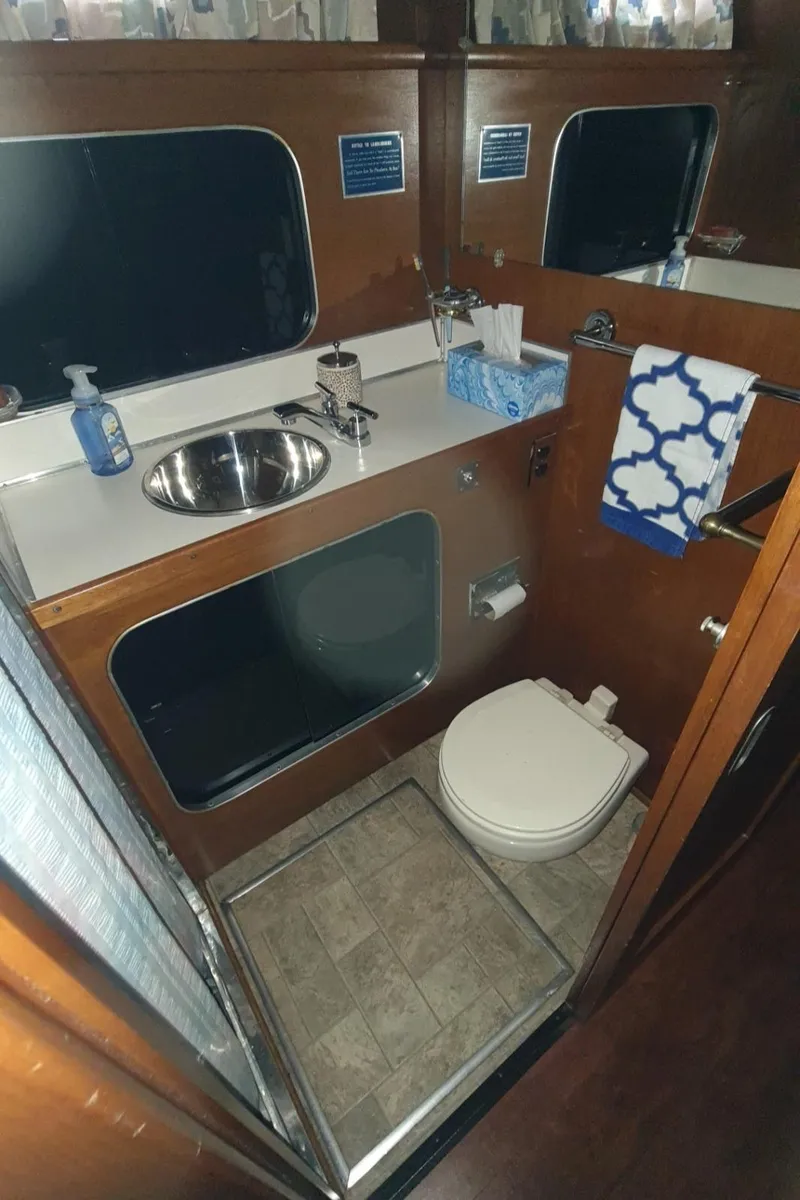 Slide: The Image of 1965 Chris-Craft 56 Roamer yacht bathroom with sink, toilet, and mirror. - 24