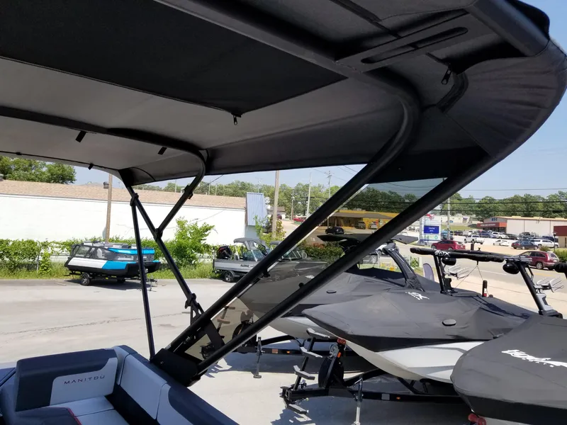 Slide: The Image of 2025 Manitou Cruise boat with canopy in a dealership lot. - 21