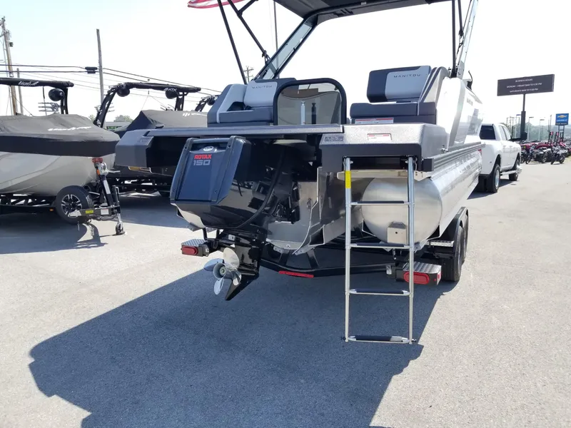 Slide: The Image of 2025 Manitou Cruise pontoon boat rear view with outboard motor and ladder. - 25