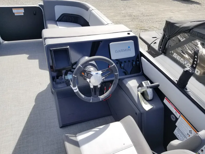 Slide: The Image of 2025 Manitou Cruise boat dashboard with Garmin navigation system and steering wheel. - 26