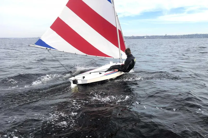 Slide: The Image of Person sailing 2023 Dinghy Rocket Board Boat with red and white striped sail. - 5