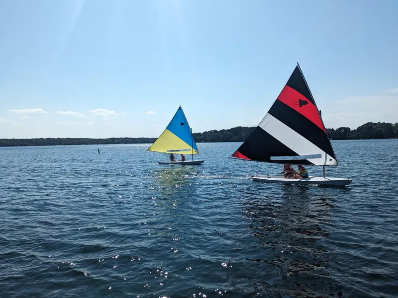 Slide: The Image of Two colorful Dinghy Rocket Board Boats sailing on a sunny lake, 2025 model. - 6