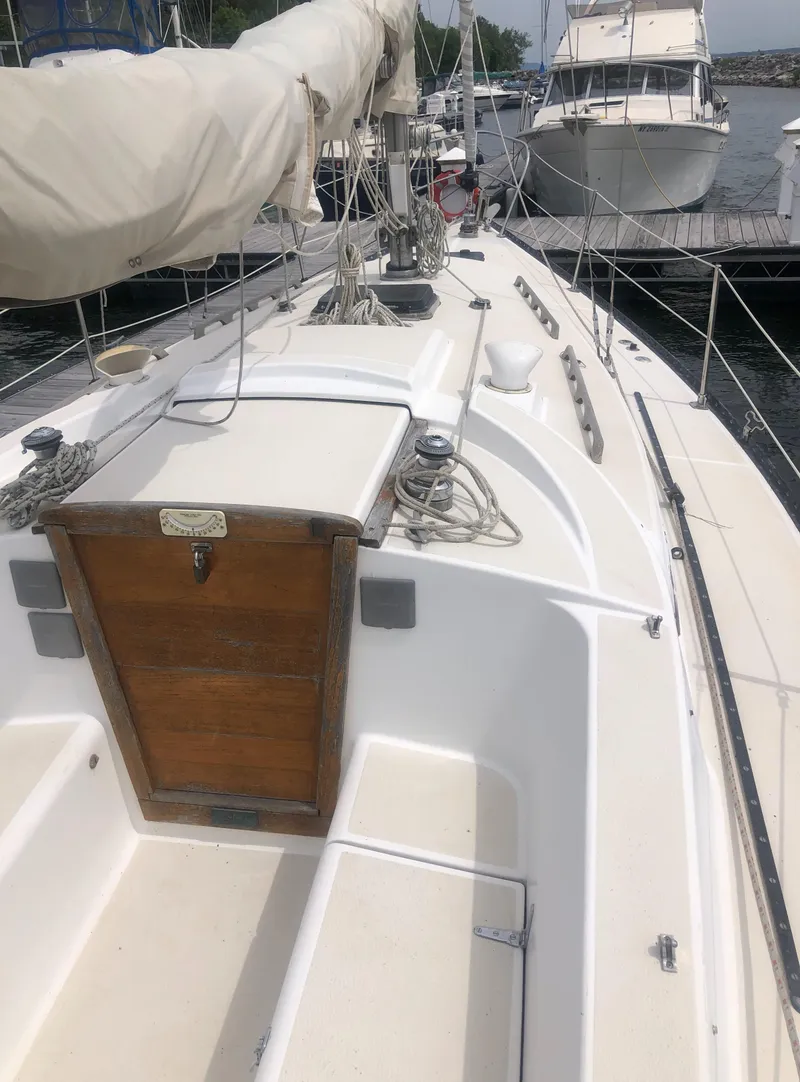 Slide: The Image of 1980 Tartan 33 sailboat docked, showcasing deck and cabin details. - 10