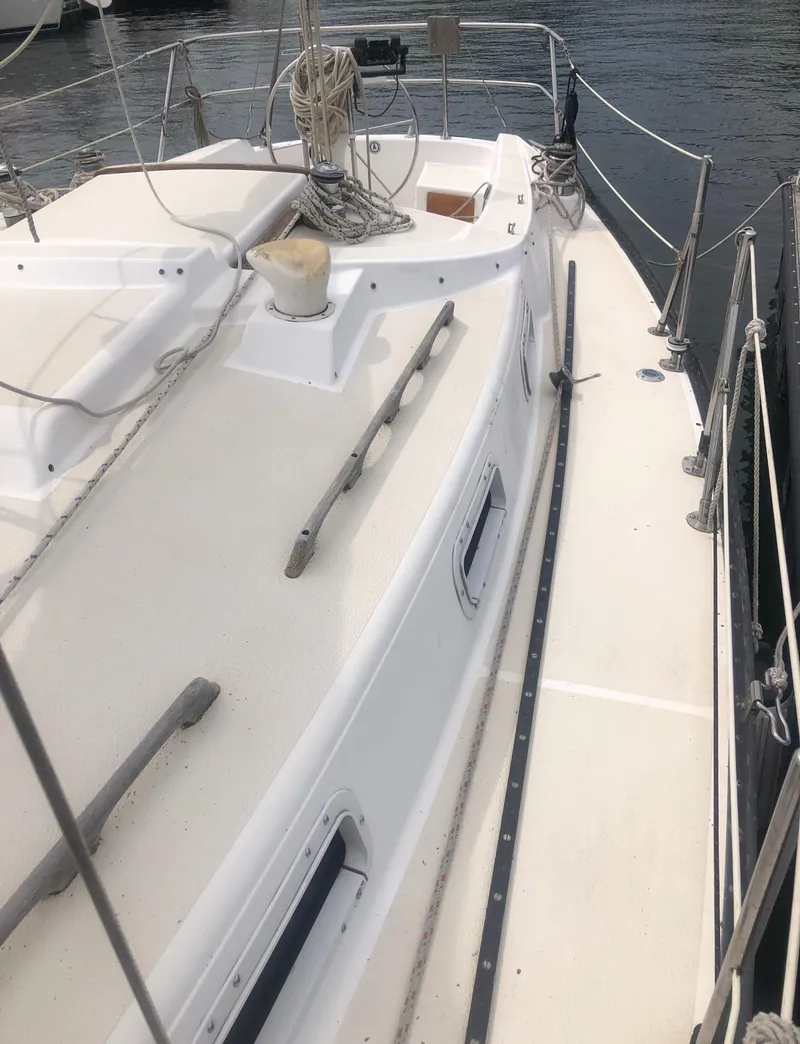 Slide: The Image of 1980 Tartan 33 sailboat deck with railing, docked by the water. - 14