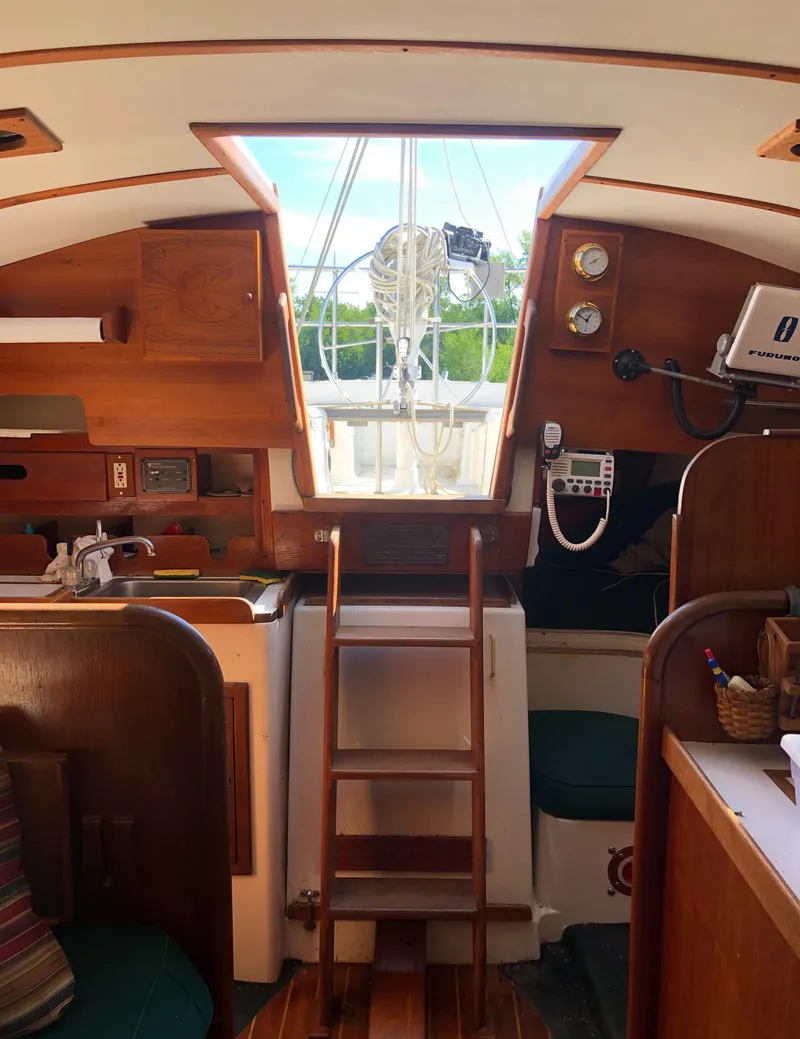 Slide: The Image of Interior of a 1980 Tartan 33 sailboat, featuring wooden finishes and nautical instruments. - 16