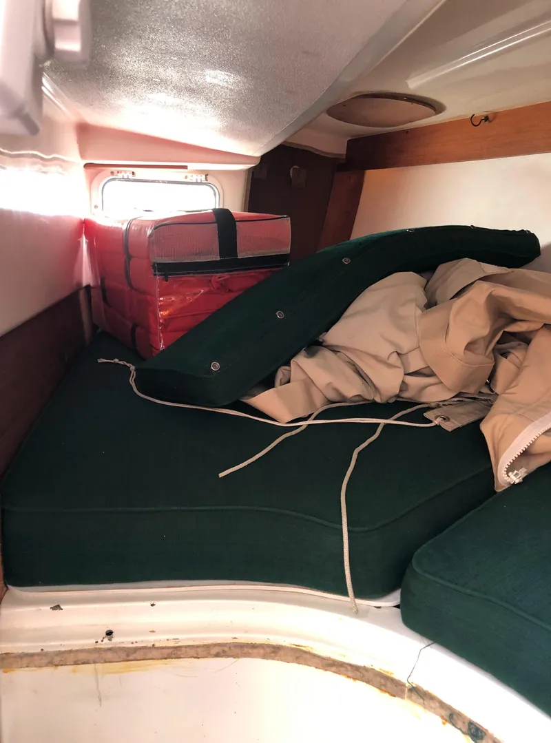 Slide: The Image of Interior of 1980 Tartan 33 sailboat with green cushions and storage items. - 19