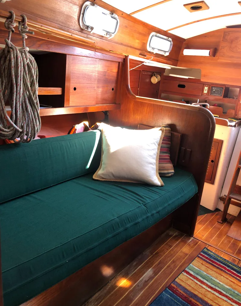 Slide: The Image of Interior of a 1980 Tartan 33 sailboat with green seating and wooden accents. - 21