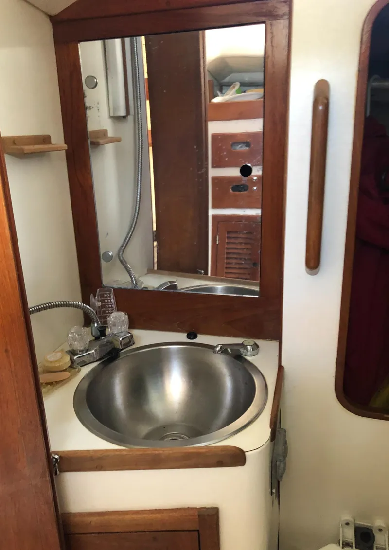 Slide: The Image of 1980 Tartan 33 yacht bathroom with stainless steel sink and wooden accents. - 27