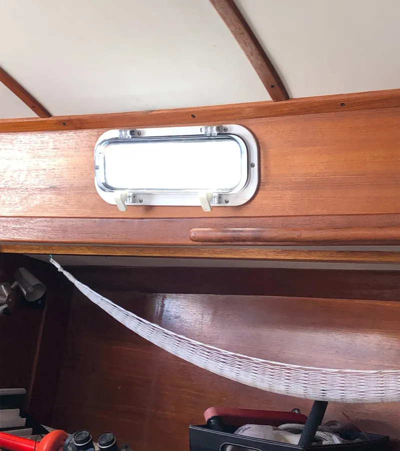 Slide: The Image of 1980 Tartan 33 interior with wooden paneling and a small window. - 40