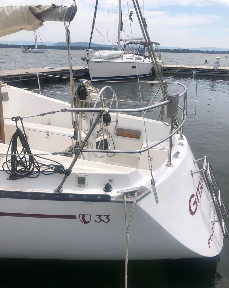 Slide: The Image of 1980 Tartan 33 sailboat docked at marina, featuring sleek design and nautical equipment. - 6