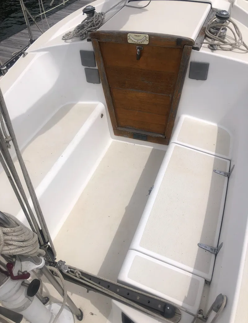 Slide: The Image of 1980 Tartan 33 sailboat cockpit with wooden hatch and white seating. - 9