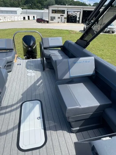Slide: The Image of 2023 Manitou 24 Explore SB boat with 250 hp Mercury engine, spacious seating area. - 6