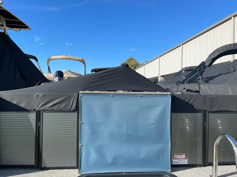Slide: The Image of 2023 Apex Marine E 818 pontoon boat covered, docked outdoors under clear blue sky. - 8