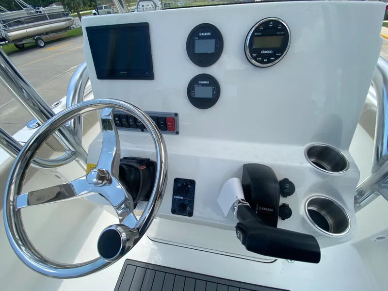 Slide: The Image of 2024 Key West 203 FS boat console with steering wheel, gauges, and controls. - 14