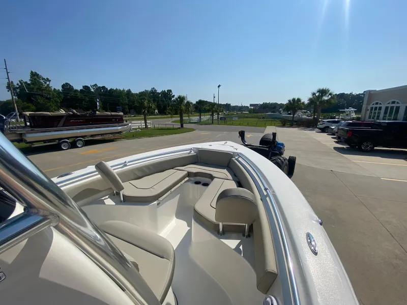 Slide: The Image of 2024 Key West 219 FS boat with beige seating, parked outdoors on a sunny day. - 18