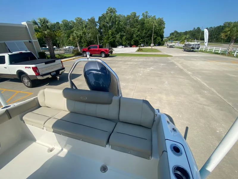 Slide: The Image of 2024 Key West 219 FS boat with rear seating and outboard motor in a parking lot. - 7