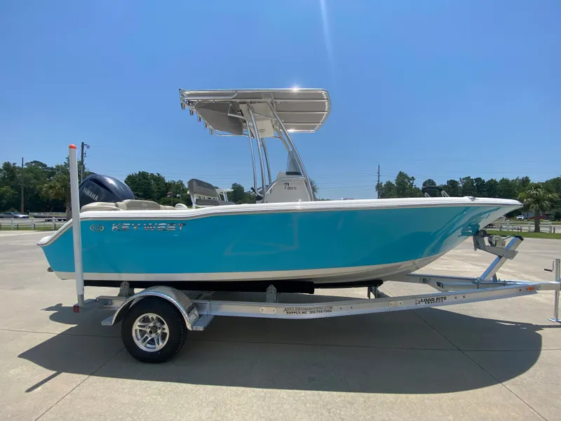 Slide: The Image of 2024 Key West 203 FS boat on a trailer under a clear blue sky. - 3
