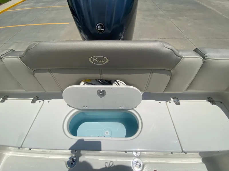 Slide: The Image of 2024 Key West 203 FS boat with open storage compartment and cushioned seating. - 9
