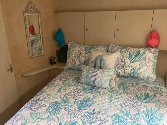 Slide: The Image of 1998 Ocean Yachts 45 Super Sport bedroom with coastal-themed bedding. - 12