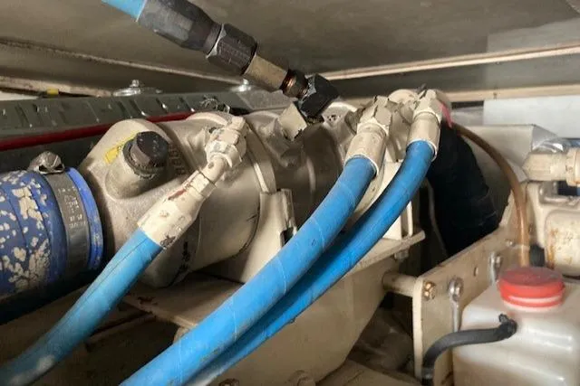 Slide: The Image of Engine compartment of a 1998 Ocean Yachts 45 Super Sport with blue hoses and mechanical components. - 24