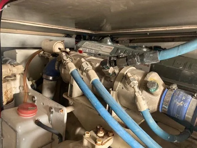 Slide: The Image of Engine compartment of a 1998 Ocean Yachts 45 Super Sport with blue hoses and mechanical components. - 23