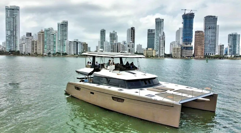 Slide: The Image of 2017 Fountaine Pajot Ipanema 58 Power Catamaran cruising near city skyline. - 1