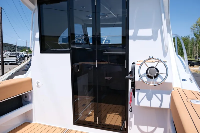 Slide: The Image of 2023 Makaira Gen3 800 boat interior with glass door and steering wheel. - 12