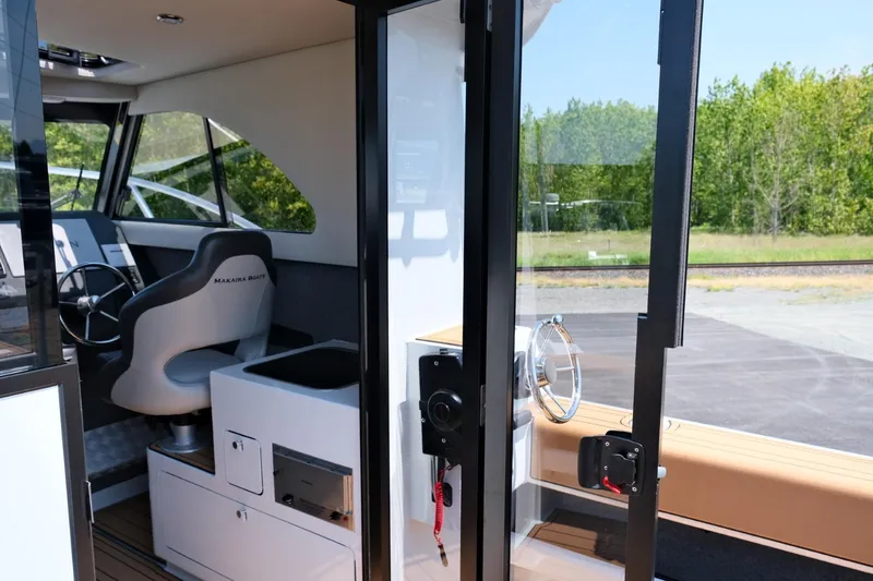 Slide: The Image of Interior view of 2023 Makaira Gen3 800 boat, featuring modern helm and seating. - 14