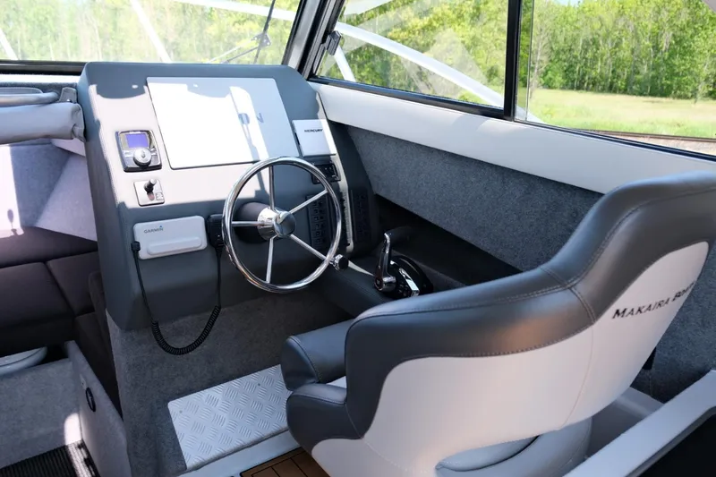 Slide: The Image of 2023 Makaira Gen3 800 boat interior with steering wheel and captain's chair. - 19