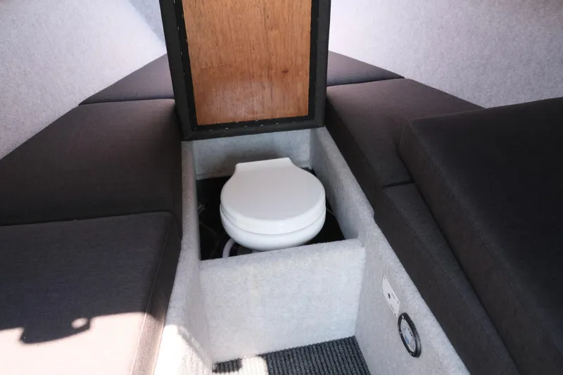 Slide: The Image of 2023 Makaira Gen3 800 boat interior with compact toilet and cushioned seating. - 24