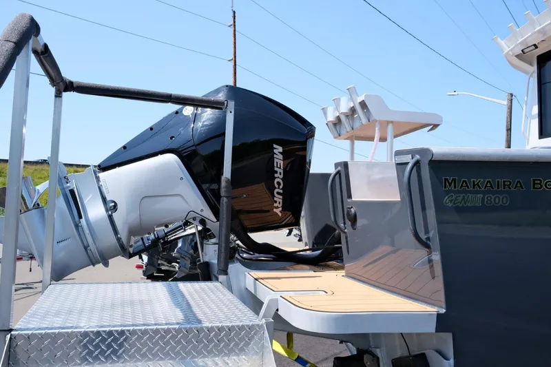 Slide: The Image of 2023 Makaira Gen3 800 boat with Mercury outboard motor, docked on a sunny day. - 8