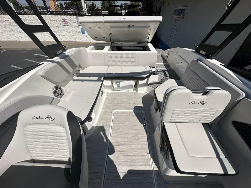 Slide: The Image of 2024 Sea Ray SPX 230 boat interior with white seating and open storage compartments. - 17