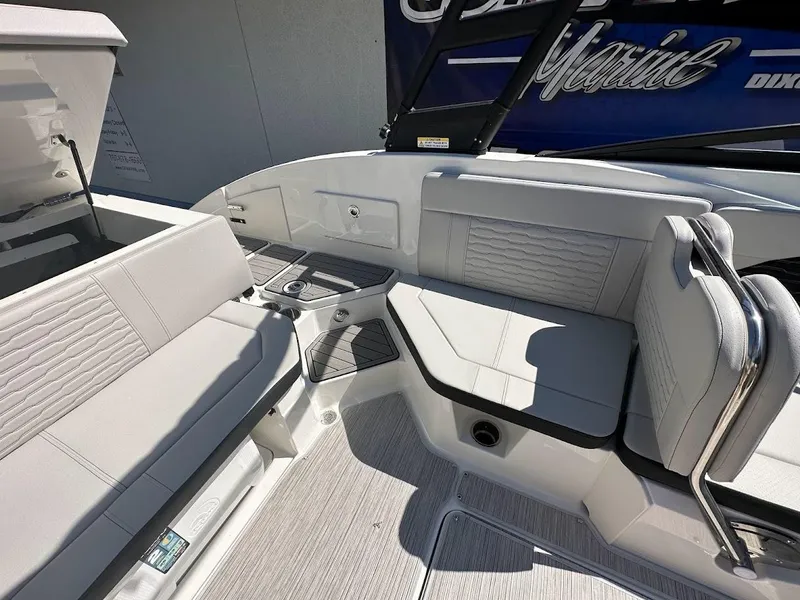 Slide: The Image of 2024 Sea Ray SPX 230 boat interior with white seating and storage compartments. - 21