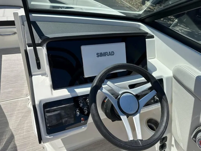 Slide: The Image of 2024 Sea Ray SPX 230 boat dashboard with Simrad display and steering wheel. - 23