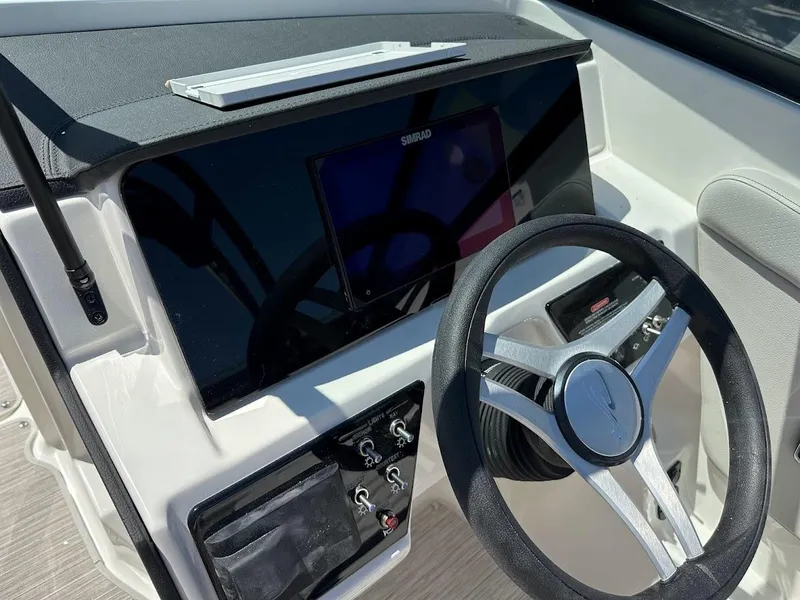 Slide: The Image of 2024 Sea Ray SPX 230 boat dashboard with steering wheel and control panel. - 24