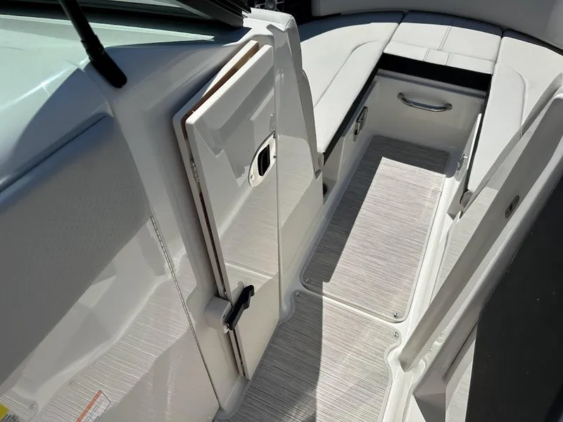 Slide: The Image of 2024 Sea Ray SPX 230 boat interior with white seating and storage compartments. - 26