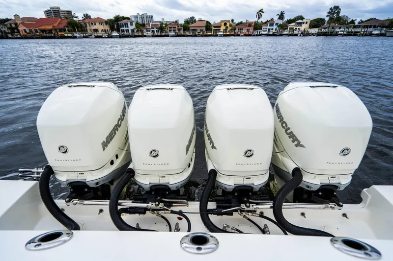 Slide: The Image of 2016 Boston Whaler 420 Outrage with four Mercury outboard engines on a waterfront. - 19