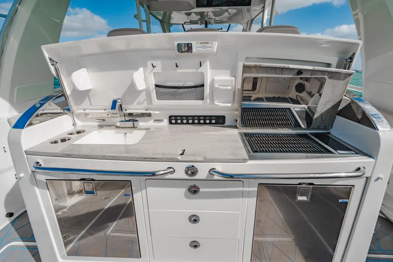 Slide: The Image of 2016 Boston Whaler 420 Outrage outdoor kitchen with grill and storage. - 37