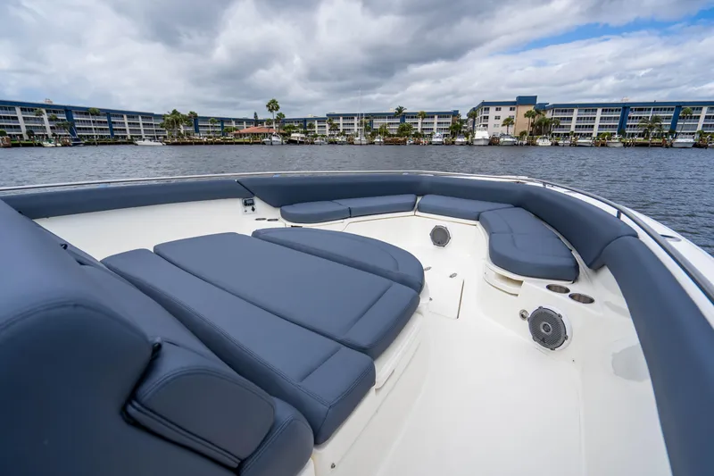 Slide: The Image of 2016 Boston Whaler 420 Outrage boat with spacious seating, docked near waterfront buildings. - 42