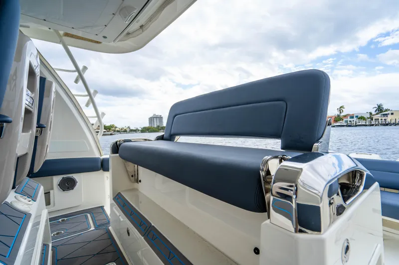 Slide: The Image of 2016 Boston Whaler 420 Outrage boat interior with blue seating, docked by waterfront homes. - 46
