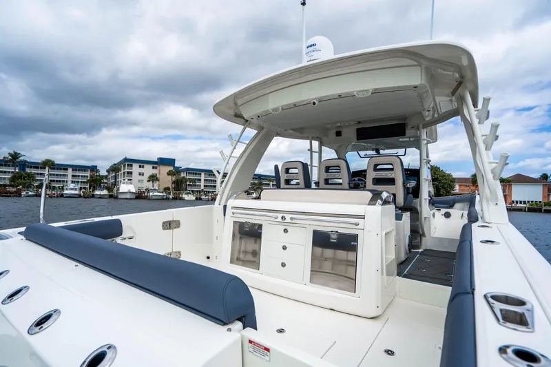 Slide: The Image of 2016 Boston Whaler 420 Outrage boat interior with seating and storage, docked by waterfront buildings. - 48